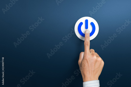 Hand of the businessman pressing power button. Start up business concept photo