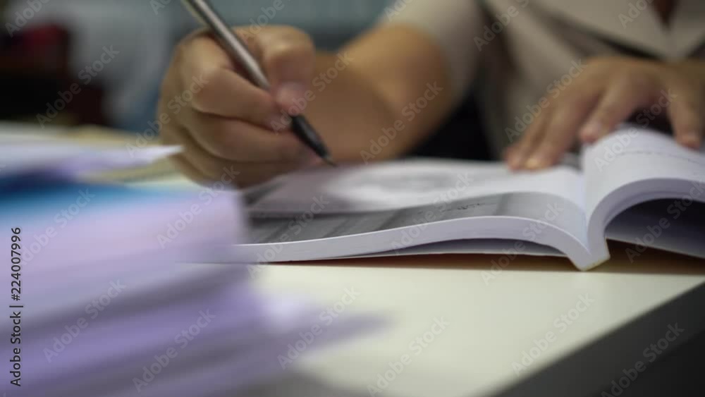 Education for reading book and Learning Studying concept : Asian student read a textbook on desk in library for learning by self at university or college Education for reading book and Learning Studying concept : Asian student read a textbook on desk in library for learning by self at university or college