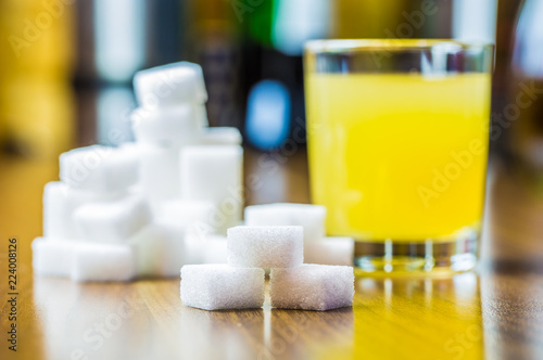 ein Glas mit Saft und viel Würfelzucker sind auf einem Tisch photo
