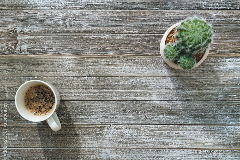 Coffee mug and cactus plant on a wooden desk overhead view Coffee mug and cactus plant on a wooden desk overhead view