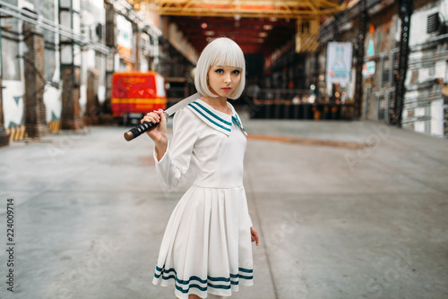 Anime girl with sword poses on abandoned factory