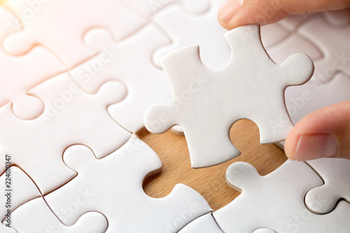 Hand put the last piece of jigsaw puzzle to complete the mission, Business solutions, success and strategy concept