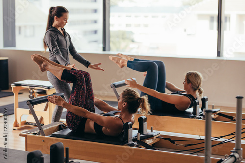 Pilates trainer instructing women at the gym photo