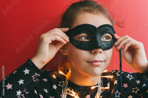 girl in masquerade mask on a red background