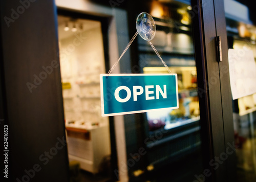 Open sign hanging in a door of shop