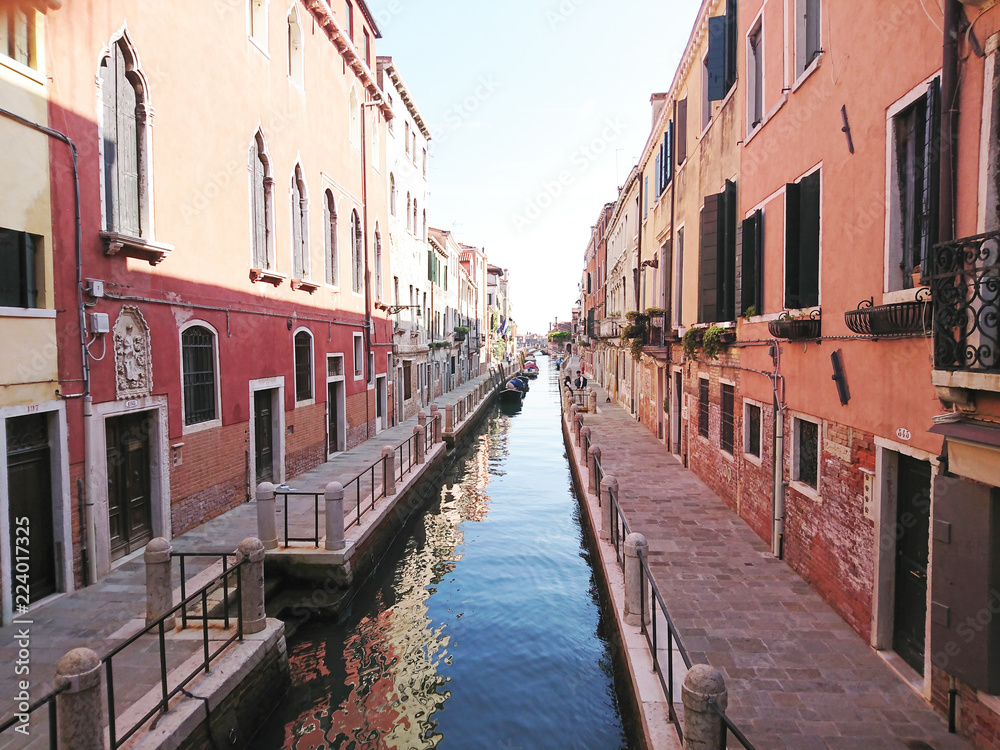 Naklejka premium Widok na historyczną architekturę i kanał między antycznymi budynkami w Wenecja, Włochy podczas radosnych wakacji w słonecznym dniu.