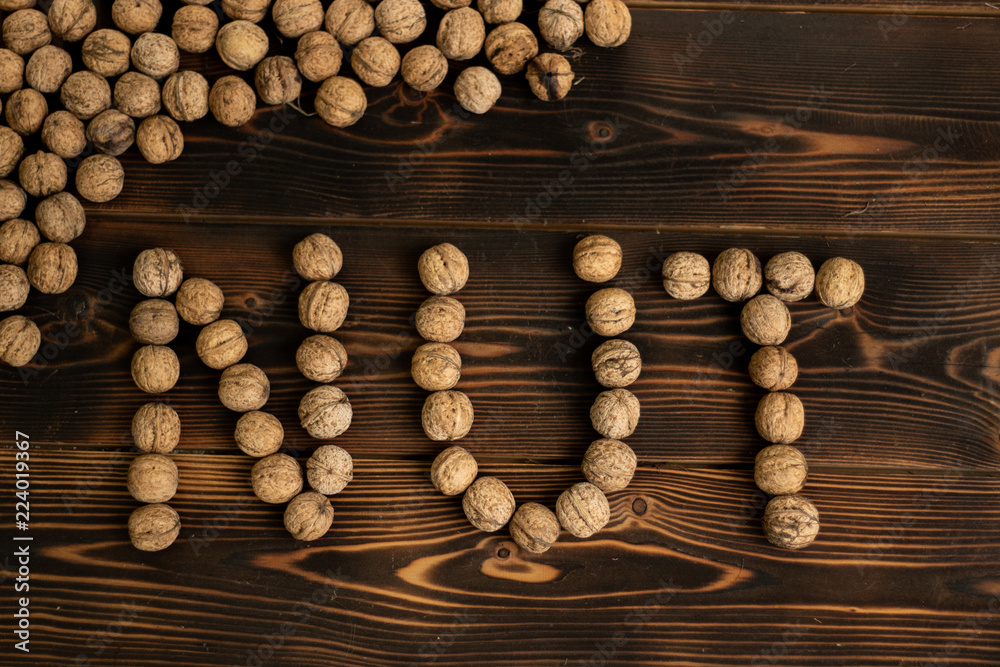 The inscription Nut made of walnuts on a wooden background The inscription Nut made of walnuts on a wooden background