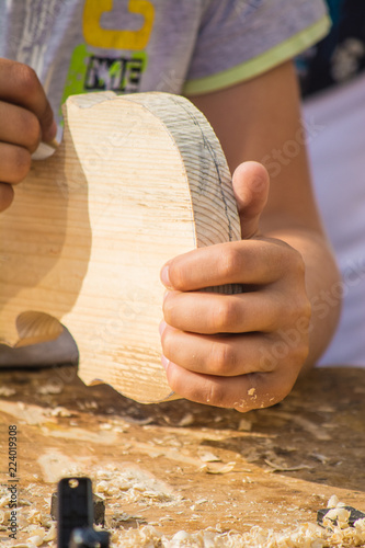 Children learn to make custom violin and other musical instruments in outdoor fablab classes. Joiner's training on makerfaire. photo