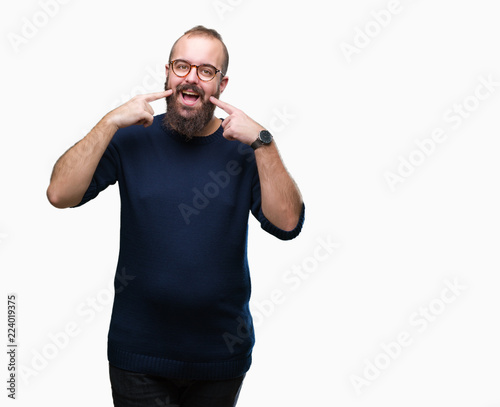 Young caucasian hipster man wearing sunglasses over isolated background smiling confident showing and pointing with fingers teeth and mouth. Health concept.