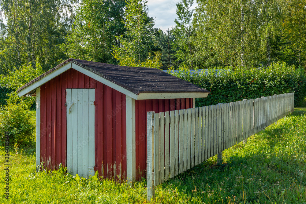 A typical red garden house in a farm in Finland A typical red garden house in a farm in Finland