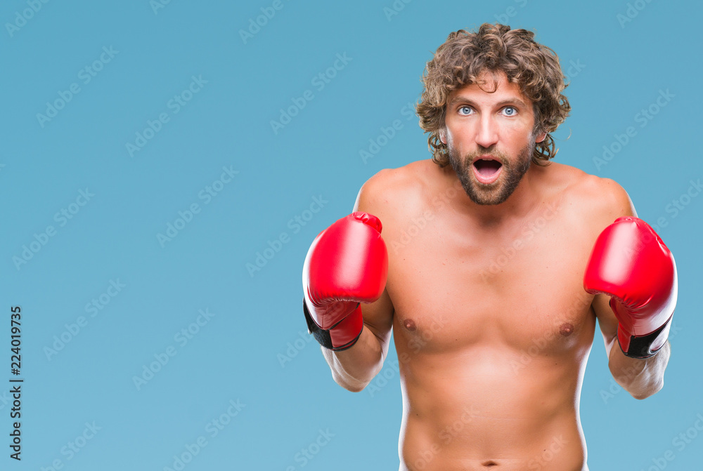Handsome hispanic boxer man wearing boxing gloves over isolated background scared in shock with a surprise face, afraid and excited with fear expression Handsome hispanic boxer man wearing boxing gloves over isolated background scared in shock with a surprise face, afraid and excited with fear expression