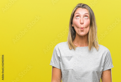 Young beautiful woman over isolated background making fish face with lips  crazy and comical gesture. Funny expression.