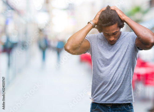 Afro american man over isolated background suffering from headache desperate and stressed because pain and migraine. Hands on head.