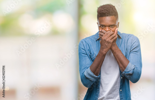 Young african american man over isolated background shocked covering mouth with hands for mistake. Secret concept. © Krakenimages.com