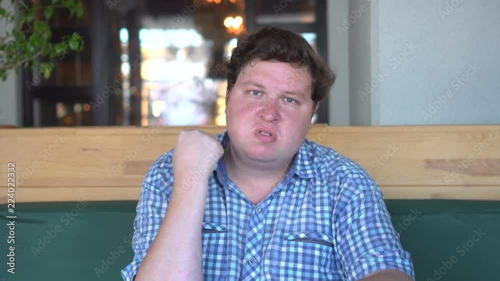 portrait of angry fat man shaking his fist in cafe or restaurant portrait of angry fat man shaking his fist in cafe or restaurant