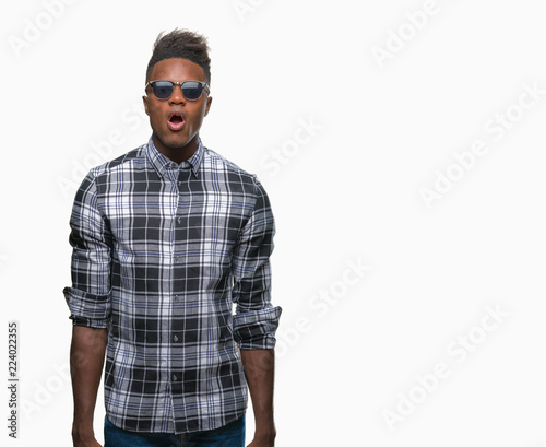 Young african american man wearing sunglasses over isolated background afraid and shocked with surprise expression, fear and excited face.