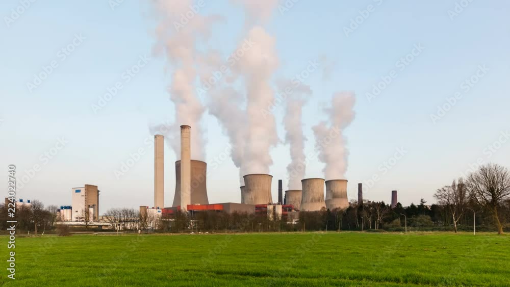 Day to night time lapse sequence of a large coal-fired power plant with a lot of steam and deep blue sky in 4K. Day to night time lapse sequence of a large coal-fired power plant with a lot of steam and deep blue sky in 4K.