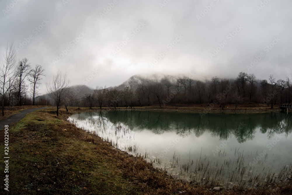 Landscape with misty morning fog in the Forest Lake or Beautiful forest lake in the morning at winter time. Azerbaijan nature.