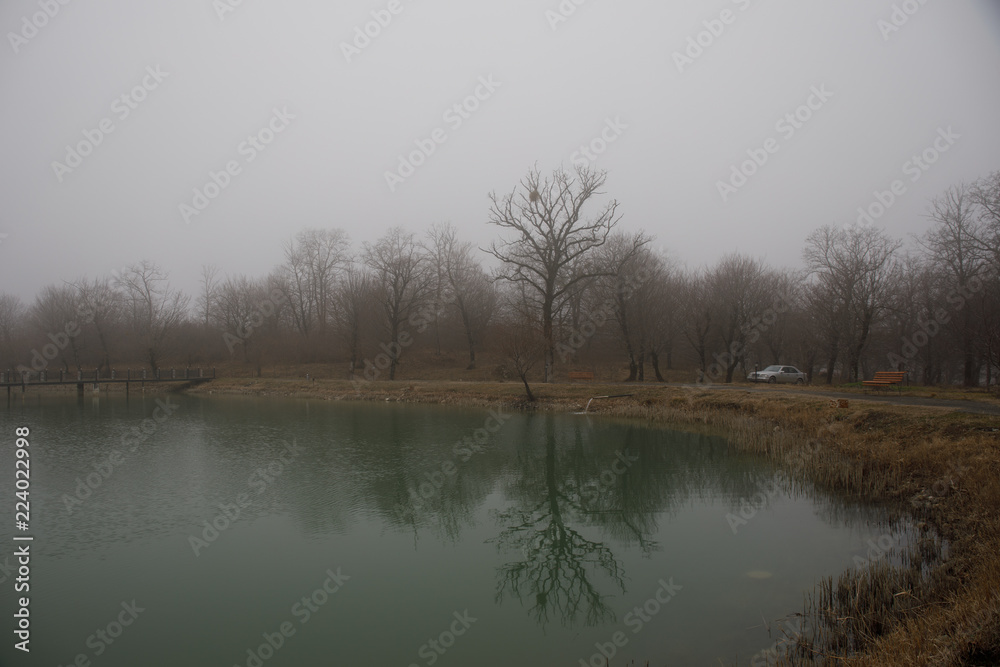 Amazing landscape of bridge reflect on surface water of lake, fog evaporate from pond make romantic scene or Beautiful bridge on lake with trees at fog. Amazing landscape of bridge reflect on surface water of lake, fog evaporate from pond make romantic scene or Beautiful bridge on lake with trees at fog.