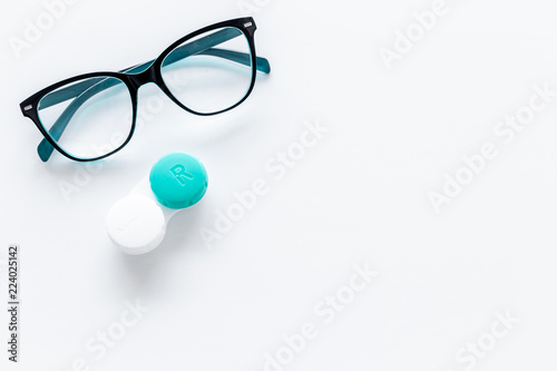 Products help see better. Glasses with transparent optical lenses and eye lenses on white background top view copy space closeup