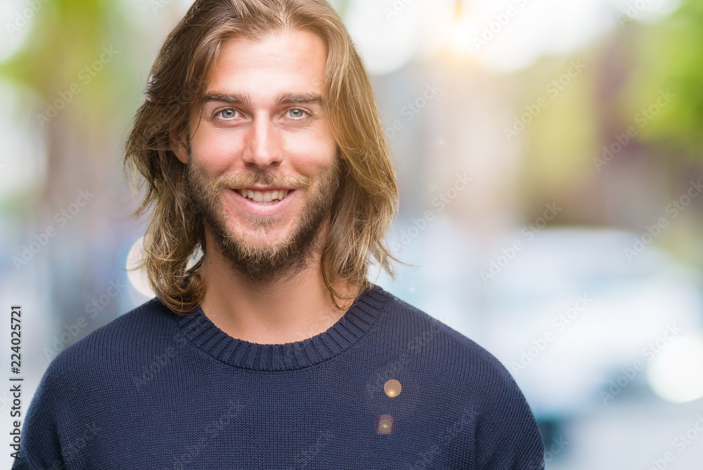Young handsome man with long hair wearing winter sweater over isolated background with a happy and cool smile on face. Lucky person. Young handsome man with long hair wearing winter sweater over isolated background with a happy and cool smile on face. Lucky person.