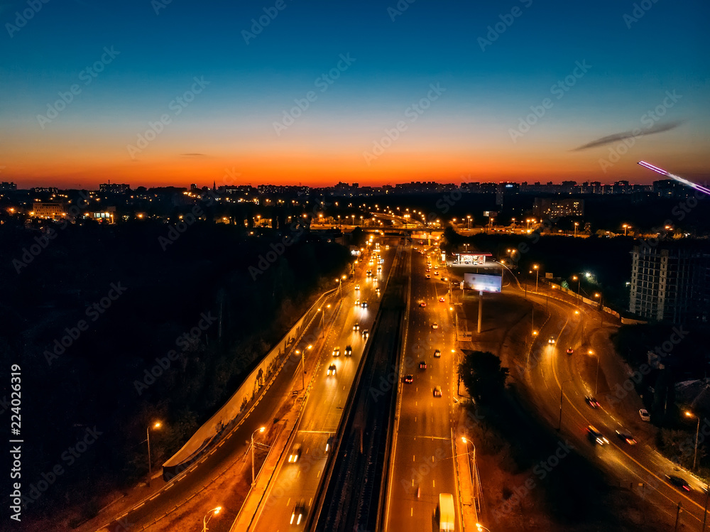 Aerial view of night city with illuminated roads and car traffic