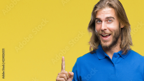 Young handsome man with long hair over isolated background pointing finger up with successful idea. Exited and happy. Number one.