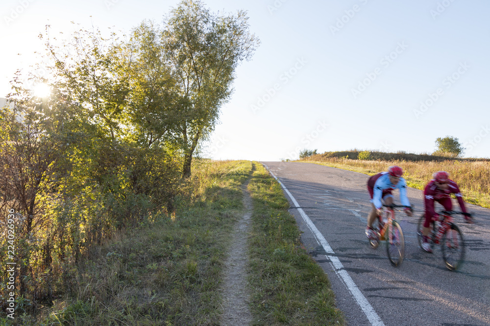 two cyclists move down the hill two cyclists move down the hill