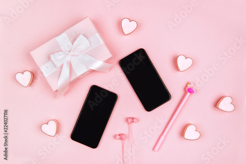 Smartphone, gifts, headphones and female accessories on pink background © Margo Basarab