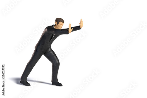 toy miniature businessman pushing, business figurine concept isolated with shadow on white background