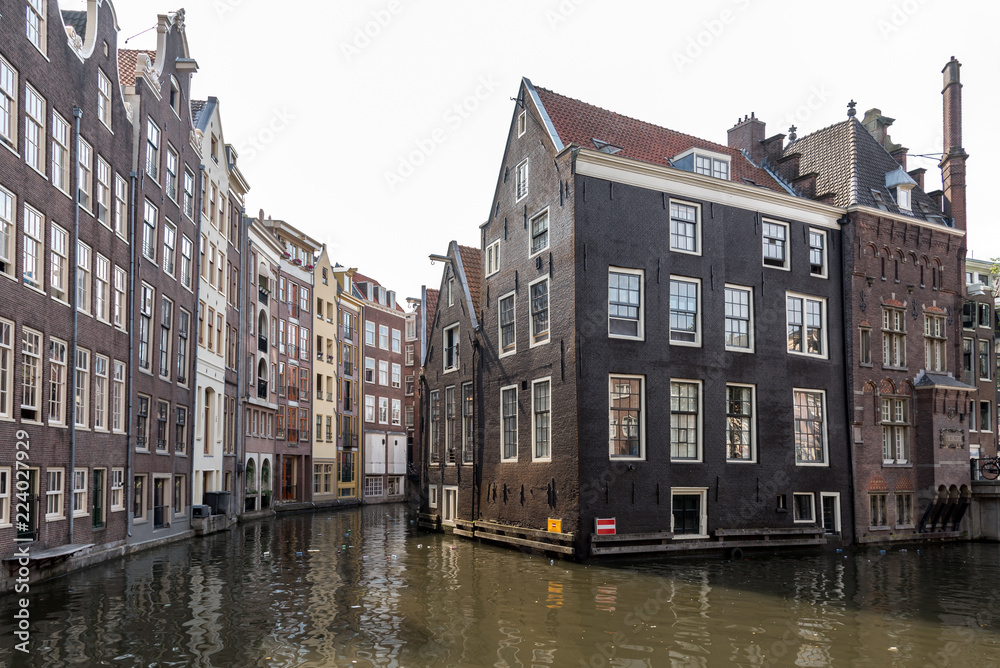 Tall houses either side of a canal in Amsterdam, Netherlands.
