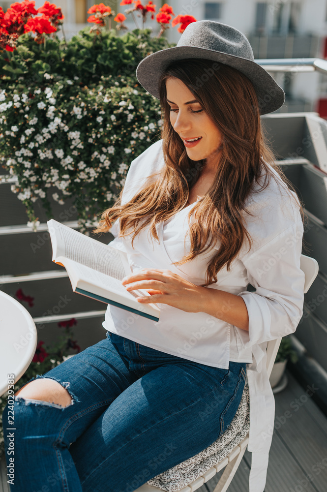 Φωτογραφία Beautiful young pregnant hipster girl, sitting relaxed on the terrace holding a