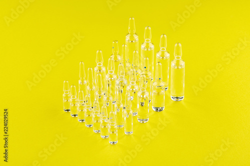 Ampoules with medicine on yellow background