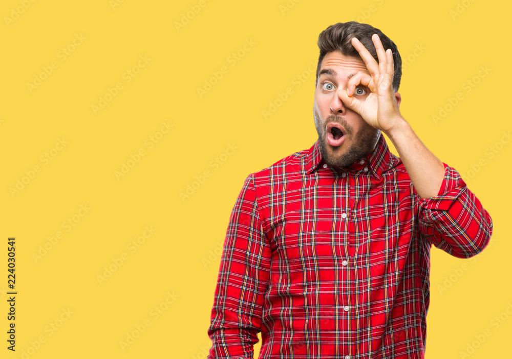 Young handsome man over isolated background doing ok gesture shocked with surprised face, eye looking through fingers. Unbelieving expression. Young handsome man over isolated background doing ok gesture shocked with surprised face, eye looking through fingers. Unbelieving expression.