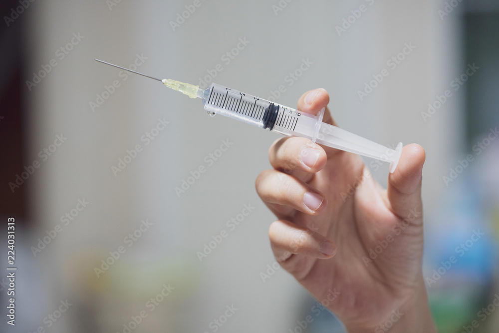 A syringe in the hands of a nurse. A syringe in the hands of a nurse.