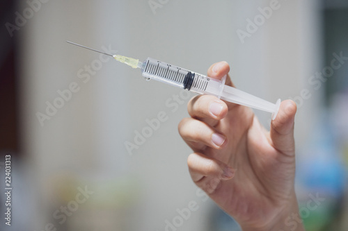 A syringe in the hands of a nurse.