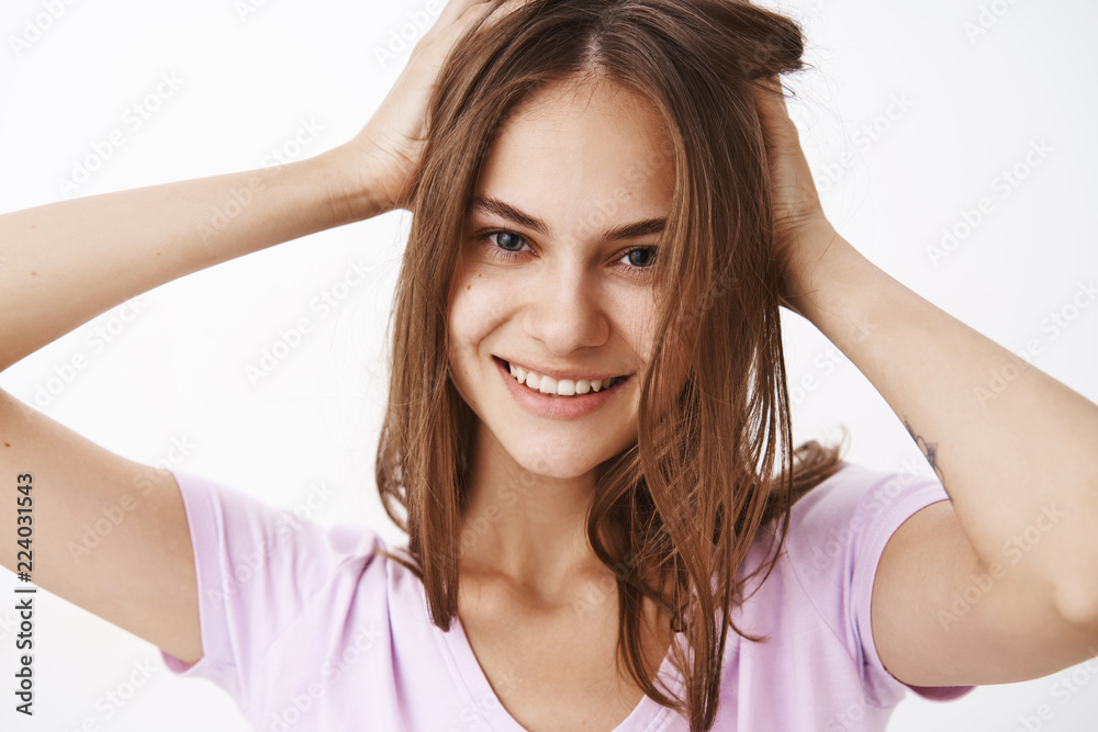Girl feeling energized and confident ready rock day. Close-up shot of self-assured feminine beautiful woman touching haircut and smiling joyfully feeling pretty getting rid of acne over grey wall