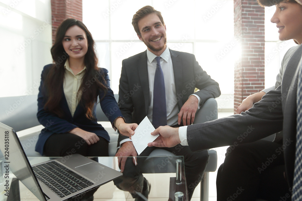 Business card being passed over between a male and female busine Business card being passed over between a male and female busine