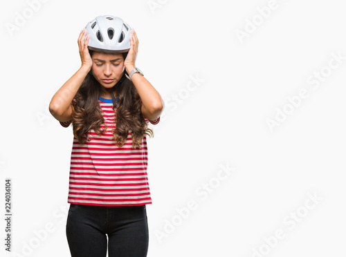 Young arab cyclist woman wearing safety helmet over isolated background suffering from headache desperate and stressed because pain and migraine. Hands on head.