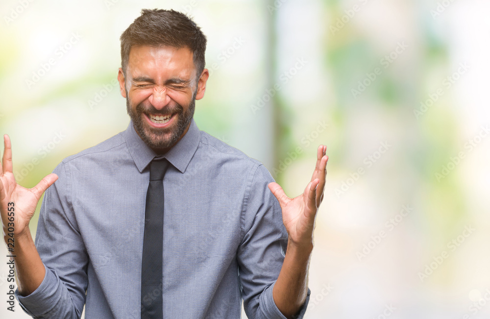 Adult hispanic business man over isolated background celebrating mad and crazy for success with arms raised and closed eyes screaming excited. Winner concept Adult hispanic business man over isolated background celebrating mad and crazy for success with arms raised and closed eyes screaming excited. Winner concept