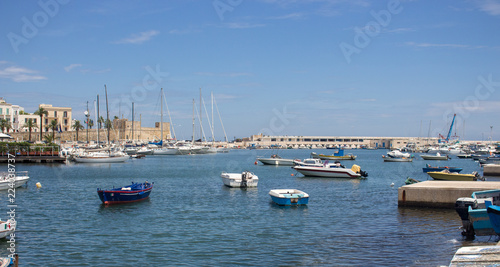 Bari, Italy - 06/16/2018: port harbor with boats and yatchs against clear blue sky. Travel and vacation concept. Sailing and fishing background. Italian seascape. 