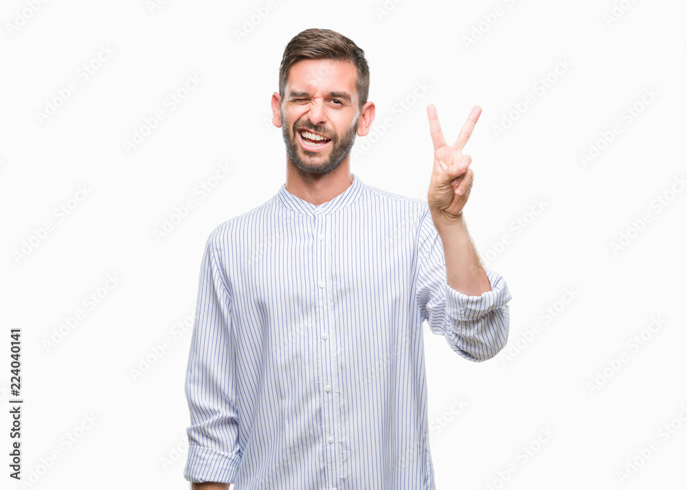 Young handsome man over isolated background smiling with happy face winking at the camera doing victory sign. Number two. Young handsome man over isolated background smiling with happy face winking at the camera doing victory sign. Number two.