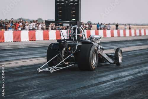 Dragster sets off on the racetrack. Dragster on the speedway. Drag wheel, torque, power, engine power. photo