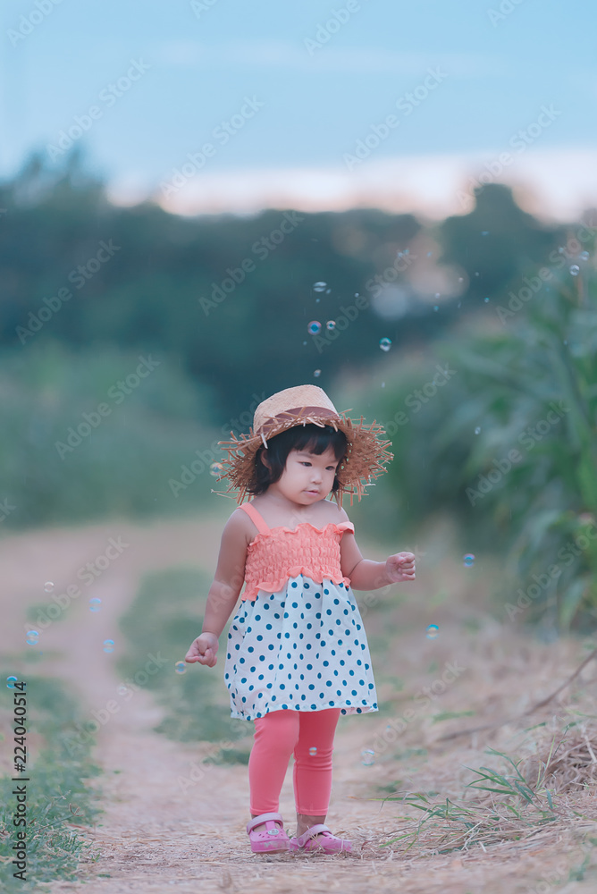 Naklejka premium Portrait of asian little girl sit on a bench at the park,Thailand people