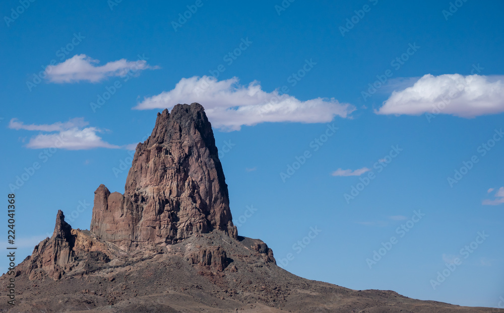 Monument Valley butte against blue sky and clouds, in the Navajo Nation on the Arizona - Utah border