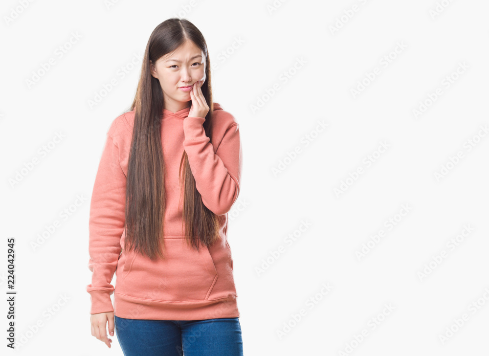 Young Chinese woman over isolated background wearing sport sweathshirt touching mouth with hand with painful expression because of toothache or dental illness on teeth. Dentist concept. Young Chinese woman over isolated background wearing sport sweathshirt touching mouth with hand with painful expression because of toothache or dental illness on teeth. Dentist concept.