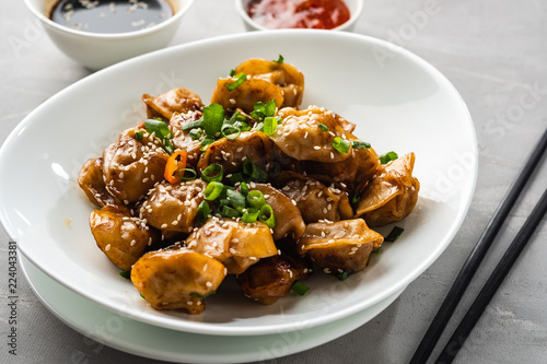 Fried dumplings with soy sauce with pepper and green onions. Asian cuisine