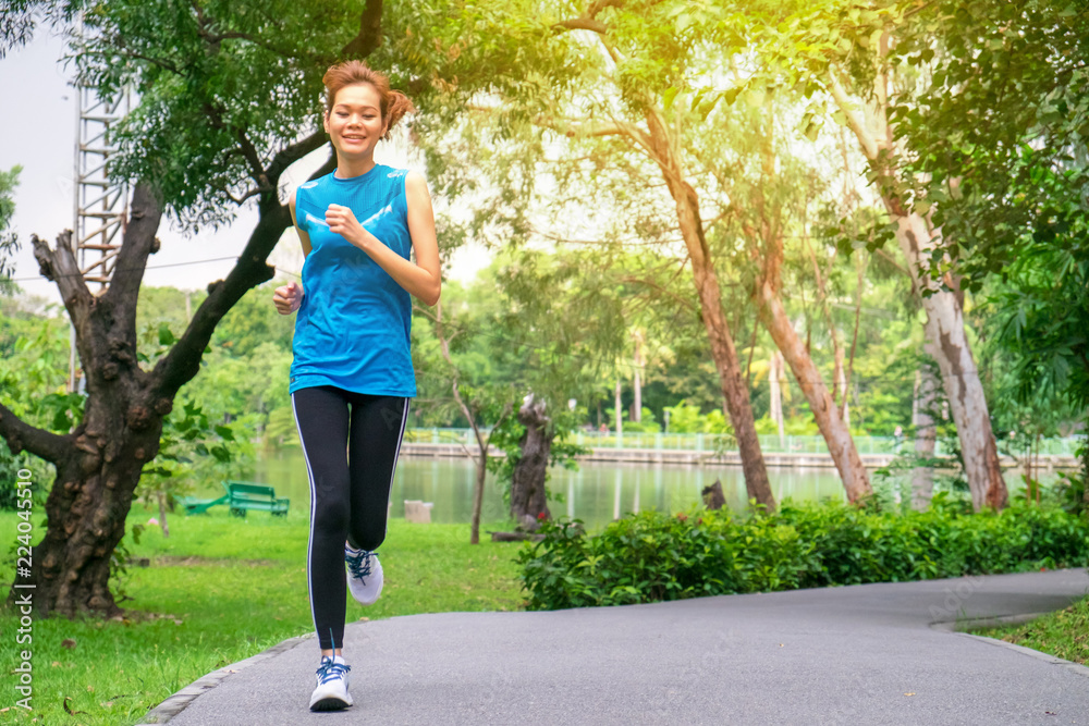 Asian Woman runner jogging at park.Healthy lifestyle fitness Concept image.