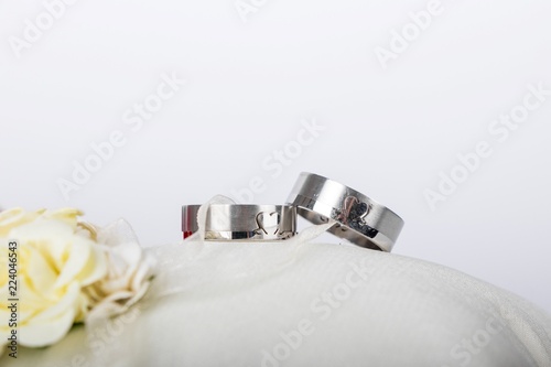  wedding rings - silver wedding rings on a white silk pillow