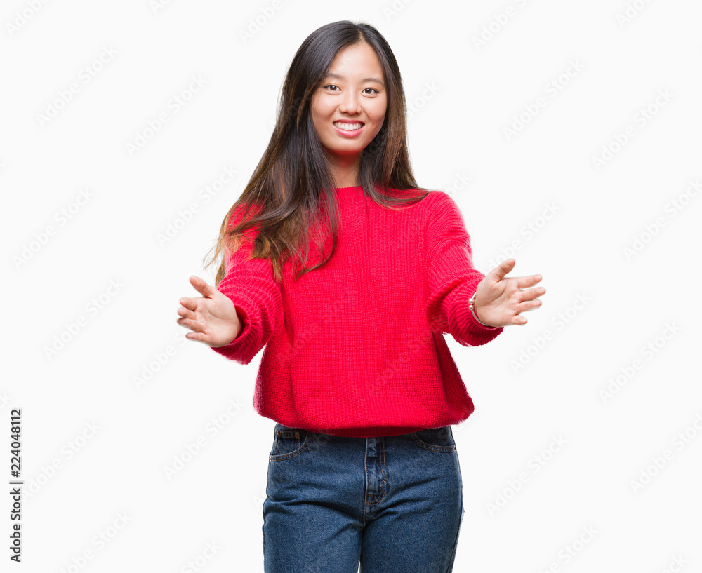 Young asian woman wearing winter sweater over isolated background looking at the camera smiling with open arms for hug. Cheerful expression embracing happiness. Young asian woman wearing winter sweater over isolated background looking at the camera smiling with open arms for hug. Cheerful expression embracing happiness.